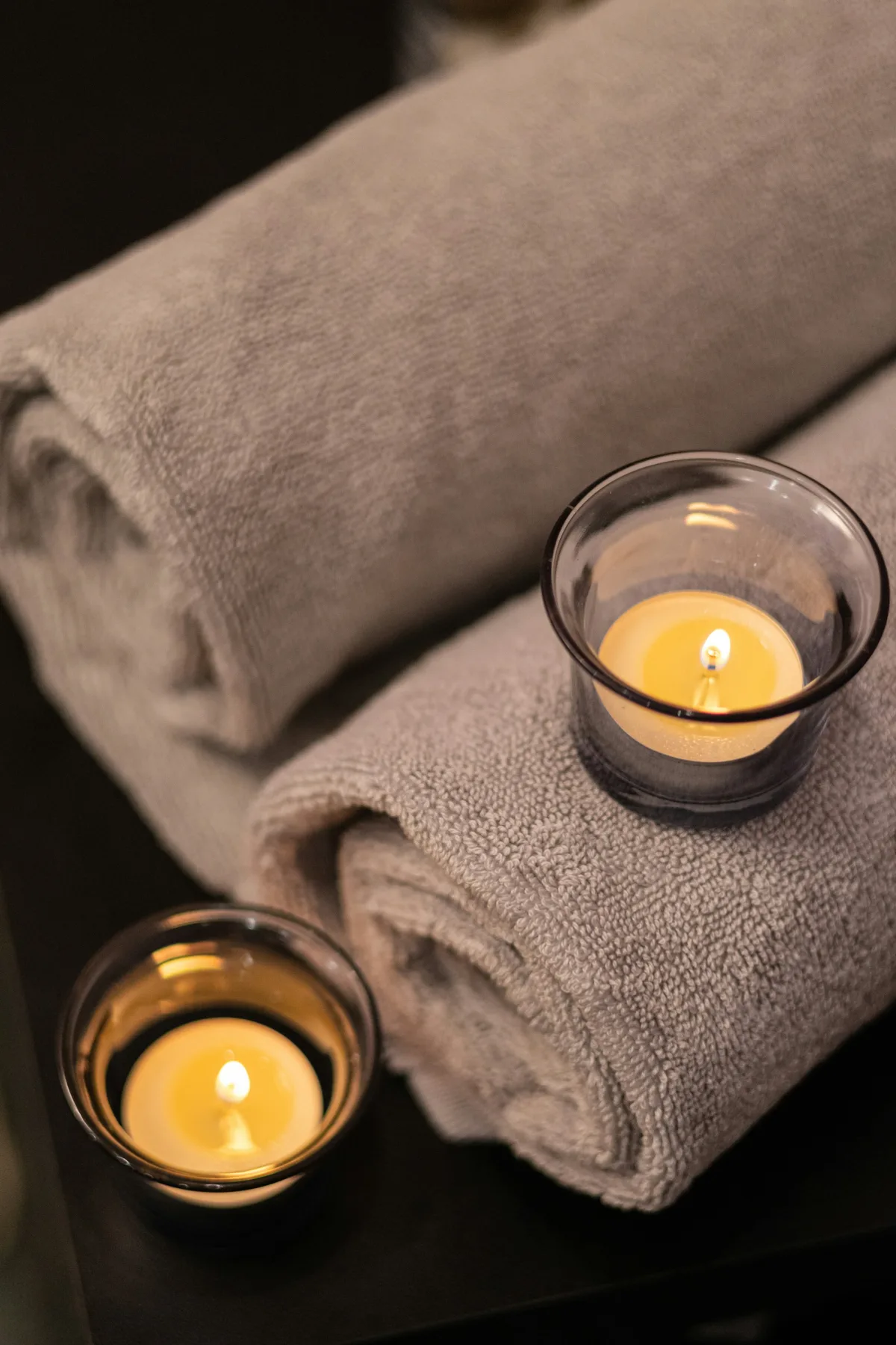Folded towels and lit candles on a table