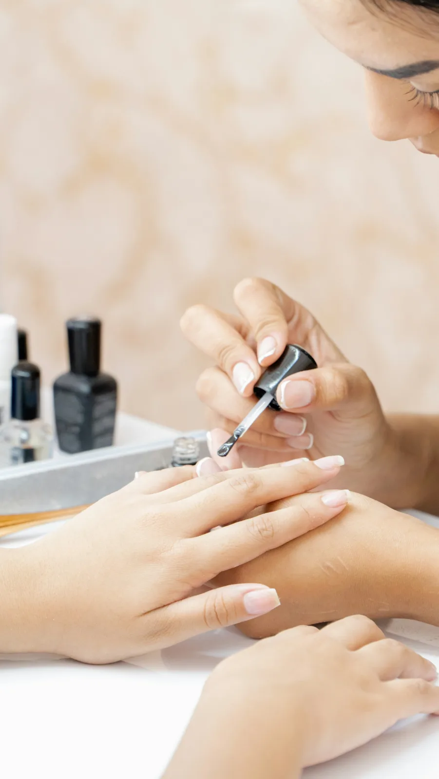 A nail technician painting a child's fingernails