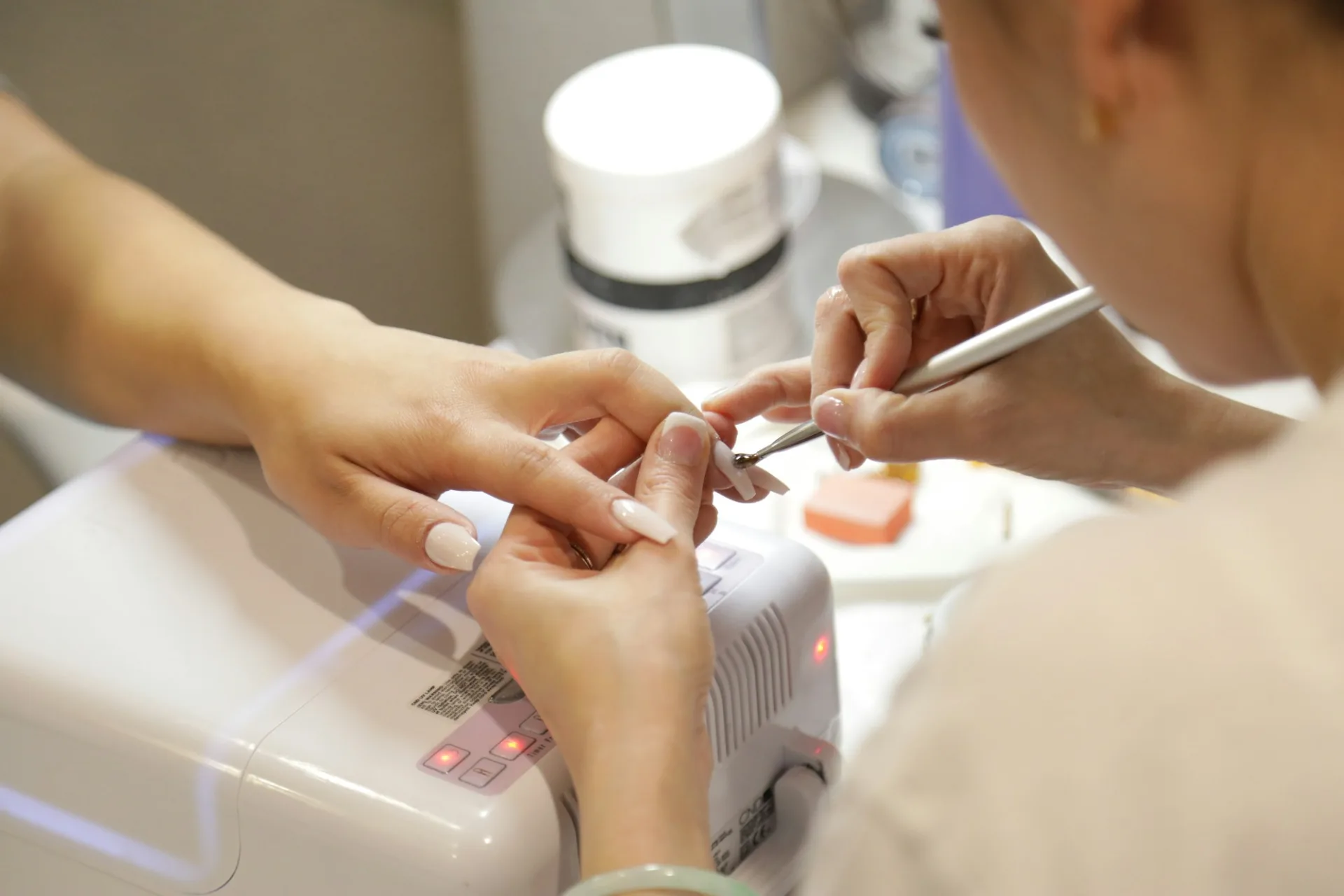 A nail technician working on a client's nails